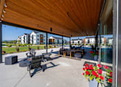 Thumbnail 60 of 64 - A patio with a wooden roof and a table with chairs. at Silverbrook Apartments, Kalispell, MT