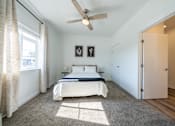 Thumbnail 14 of 64 - A bedroom with a bed, a ceiling fan, and two pictures on the wall. at Silverbrook Apartments, Kalispell, MT, 59901