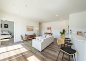 Thumbnail 3 of 64 - A living room with a white couch and a wooden floor. at Silverbrook Apartments, Kalispell 59901