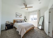 Thumbnail 11 of 64 - A bedroom with a bed, nightstand, and a ceiling fan. at Silverbrook Apartments, Montana, 59901