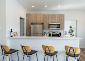 Thumbnail 5 of 64 - A kitchen with a white counter and four chairs. at Silverbrook Apartments, Kalispell, MT, 59901