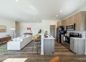 Thumbnail 4 of 64 - A modern kitchen with a white sofa and wooden cabinets. at Silverbrook Apartments, Kalispell, Montana