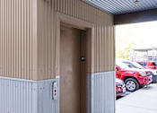 Thumbnail 18 of 23 - A brown door is open to a parking lot.