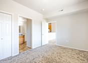 Thumbnail 12 of 23 - A spacious room with white walls and carpeted floor.