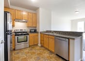 Thumbnail 14 of 23 - A kitchen with wooden cabinets and granite countertops.