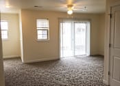 Thumbnail 1 of 3 - A room with a carpeted floor and a ceiling fan.