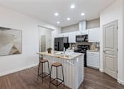 Thumbnail 4 of 61 - A kitchen with white cabinets and a marble countertop. at Verraso Village Apartments, Idaho
