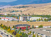 Thumbnail 1 of 31 - A road with cars and buildings in front of a mountain.