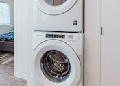 Thumbnail 28 of 31 - A white front load washing machine in a modern laundry room.