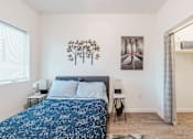 Thumbnail 12 of 31 - A bedroom with a bed, nightstands, and a painting on the wall.