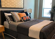 Thumbnail 6 of 33 - A small room with a bed and a window.