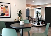 Thumbnail 14 of 33 - A green chair is in the foreground of a photo with a framed picture of a colorful elephant on the wall.