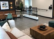 Thumbnail 17 of 33 - A living room with a couch, a coffee table, and a staircase.