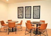 Thumbnail 22 of 33 - A room with a table and chairs and three paintings on the wall.