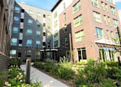 Thumbnail 25 of 33 - A modern building with a garden in front.