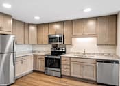 Thumbnail 46 of 51 - A kitchen with wooden cabinets and stainless steel appliances.