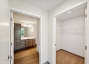 Thumbnail 17 of 51 - A white bathroom with a wooden floor and a white closet.