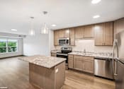 Thumbnail 28 of 51 - A kitchen with wooden cabinets and a granite countertop.