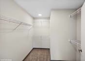 Thumbnail 43 of 51 - A white closet with a brown carpet and two shelves.