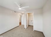 Thumbnail 4 of 51 - A room with a ceiling fan and carpeted floor.