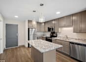Thumbnail 2 of 40 - A kitchen with a granite countertop and stainless steel appliances.