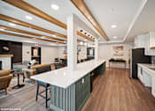 Thumbnail 4 of 40 - A modern kitchen with a white countertop and wooden flooring.