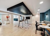 Thumbnail 5 of 40 - A modern living room with a black ceiling and wooden floors.