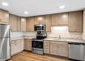Thumbnail 9 of 40 - A kitchen with wooden cabinets and stainless steel appliances.