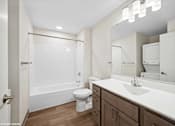 Thumbnail 11 of 40 - A white toilet sits in a bathroom next to a sink.