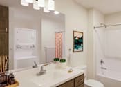 Thumbnail 17 of 40 - A bathroom with a white sink and a white toilet.