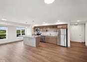 Thumbnail 19 of 40 - A modern kitchen with wooden floors and stainless steel appliances.