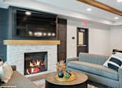 Thumbnail 39 of 40 - A cozy living room with a fireplace and a grey couch.