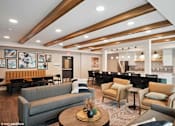 Thumbnail 40 of 40 - A modern living room with a grey sofa, wooden coffee table, and a dining area in the background.