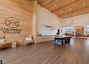 Thumbnail 12 of 30 - A wood floored room with a logo on the wall that says Columbia Village.