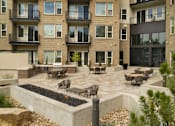 Thumbnail 4 of 67 - an outdoor patio with a fire pit and a building in the background at Cycle Apartments, Colorado