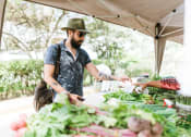 Thumbnail 9 of 9 - a man buying vegetables at a farmers market at Copestone, Garden City, ID