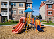 Thumbnail 22 of 26 - A playground with a red slide and a blue roof at The Alloy at Geneva, Vineyard, 84058