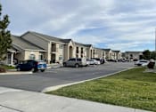 Thumbnail 4 of 4 - A row of houses with cars parked in front.