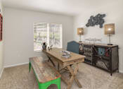 Thumbnail 30 of 37 - A room with a wooden table and a green bench.