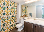 Thumbnail 19 of 37 - A bathroom with a toilet, sink, and shower curtain.