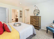 Thumbnail 31 of 37 - A bedroom with a bed, dresser, and chair.