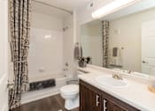 Thumbnail 35 of 37 - A bathroom with a white toilet, a white sink, and a white bathtub.