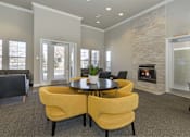 Thumbnail 23 of 37 - A living room with a fireplace and a table with chairs.