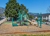 Thumbnail 2 of 37 - A playground with a green swing set and a yellow slide.