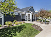 Thumbnail 16 of 37 - A house with a grey roof and white trim is surrounded by a well-manicured lawn and trees.
