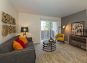 Thumbnail 10 of 37 - A living room with a grey couch, a yellow chair, and a wooden side table.