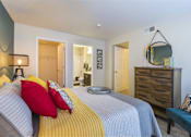 Thumbnail 12 of 37 - A bedroom with a bed, dresser, and mirror.