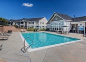 Thumbnail 14 of 37 - A swimming pool in a residential area with houses in the background.