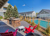 Thumbnail 6 of 37 - A backyard with a pool and a stone fireplace.