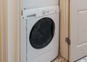 Thumbnail 26 of 29 - A white dryer and washer are in a small space.